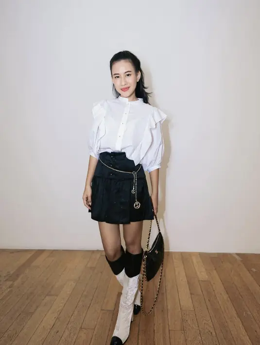 Kali ini ia terlihat begitu chic dengan kemeja ruffle dan rok pleats. [Foto: Instagram/ Shenina Cinnamon]