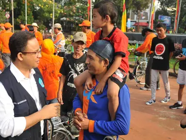 Mendikbud Anies Baswedan menyapa warga dan anaknya pada Car Free Day di kawasan Thamrin, Jakarta, Minggu (17/7). Anies mengkampanyekan imbauan kepada orangtua untuk mengantarkan anak sekolah pada hari pertama masuk sekolah. (Liputan6.com/Gempur M Surya)