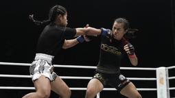 Petarung Indonesia, Priscilla Lumban Gaol, beradu pukulan dengan petarung Kamboja, Nou Srey Pov, pada laga ONE Championship di Istora Senayan, Jakarta, Jumat (3/5). Priscilla menang mutlak atas lawannya. (Bola.com/Yoppy Renato)