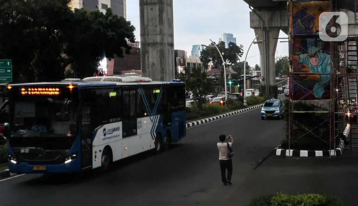 Warga mengabadikan mural di tiang jalan layang di kawasan Lapangan Bhayangkara, Mabes Polri, Jakarta, selasa (2/11/2021). Selama ini seni mural kurang mendapatkan tempat di fasilitas-fasilitas umum dan Pembuatan Mural ini bagian dalam rangka Bhayangkara Mural Festival 2021. (Liputan6.com/Johan Tallo