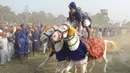 Atraksi berkuda dari anggota militer tradisional Sikh saat perayaan Fateh Divas di Amritsar (20/10). Para anggota militer ini menujukan aksi berkuda mereka untuk meramaikan perayaan Fateh Divas. (AFP/Narinder Nanu)