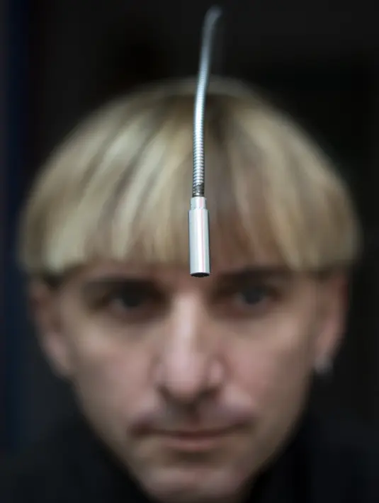 Neil Harbisson, orang pertama di dunia yang memasang antena di tengkoraknya, berpose di Mataro dekat Barcelona pada 23 September 2021. Antena itu telah melekat secara permanen di kepala Neil Harbisson sejak 2004. (Josep LAGO / AFP)