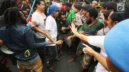 Polisi berusaha membubarkan unjuk rasa massa FRI-WP dan AMP di Jalan Medan Merdeka Barat, Jakarta, Selasa (15/8). Kericuhan dipicu akibat massa aksi yang ingin berunjuk rasa di depan Istana Negara, namun dilarang polisi. (Liputan6.com/Immanuel Antonius)