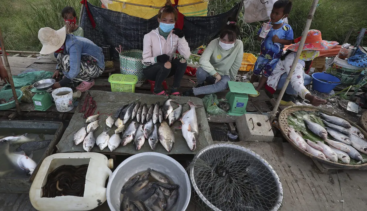 Etnis Vietnam menjual ikan di sepanjang trotoar dekat desa Prek Pnov di Phnom Penh, Kamboja, Kamis (5/8/2021). Prek Pnov terkenal dengan peternakan ikannya dan memasok banyak pasar di Phnom Penh. (AP Photo/Heng Sinith)