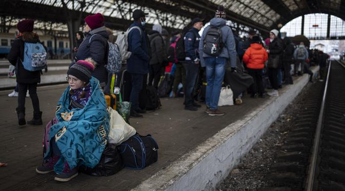Penumpang menunggu di peron stasiun kereta api Lviv, di Lviv, Ukraina barat pada Minggu, 27 Februari 2022. Dengan mobil, kereta api, dan berjalan kaki, puluhan ribu pengungsi Ukraina mencari keselamatan di negara-negara tetangga Ukraina saat invasi Rusia. (AP Photo/Bernat Armangue)