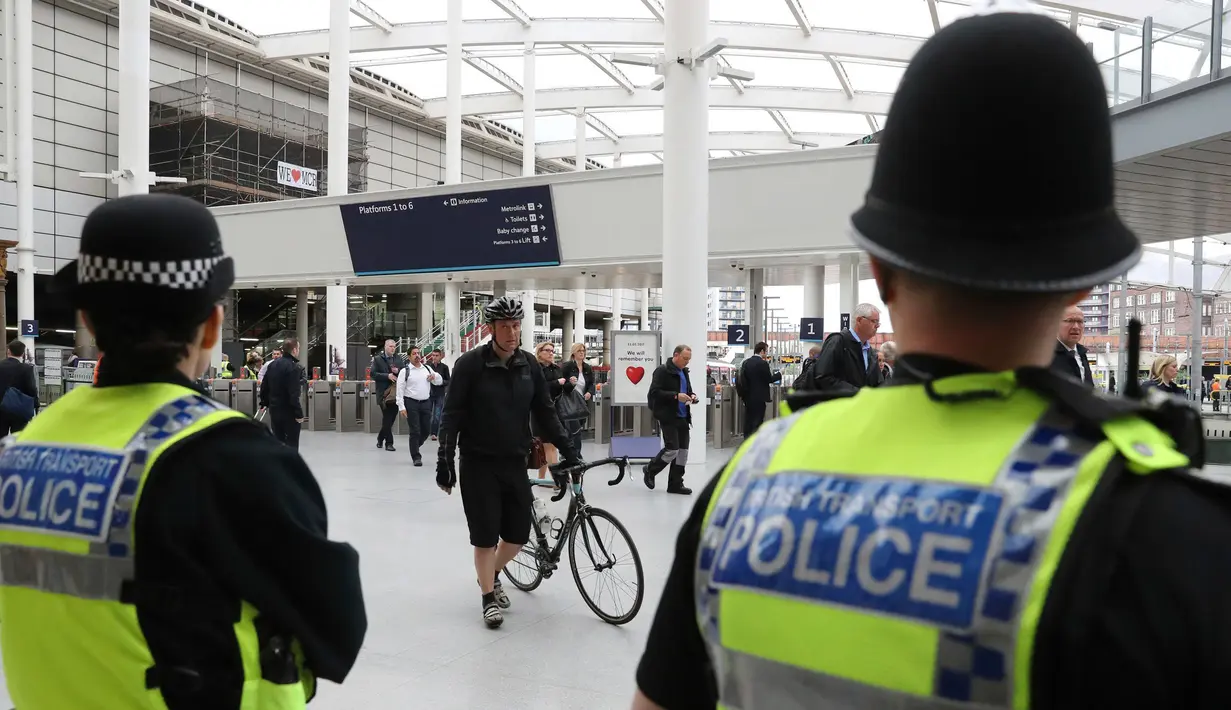 Petugas keamanan mengamati aktivitas di stasiun kereta Manchester Victoria, Inggris, (30/5). Sempat ditutup, stasiun kereta Manchester Victoria kembali dibuka setelah lebih dari sepekan insiden bom bunuh diri di Manchester Arena (Owen Humphreys/PA via AP)