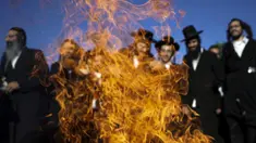 Orang-orang Yahudi Ultra Ortodoks menari di sekitar api unggun saat perayaan Lag BaOmer di situs makam tradisional Rabbi Shimon Bar Yochai di Gunung Meron, Israel, Kamis (19/5/2022). Orang Israel menyalakan api unggun selama perayaan Lag BaOmer untuk memperingati berakhirnya wabah yang dikatakan telah memusnahkan orang Yahudi di zaman Romawi. (AP Photo/Ariel Schalit)