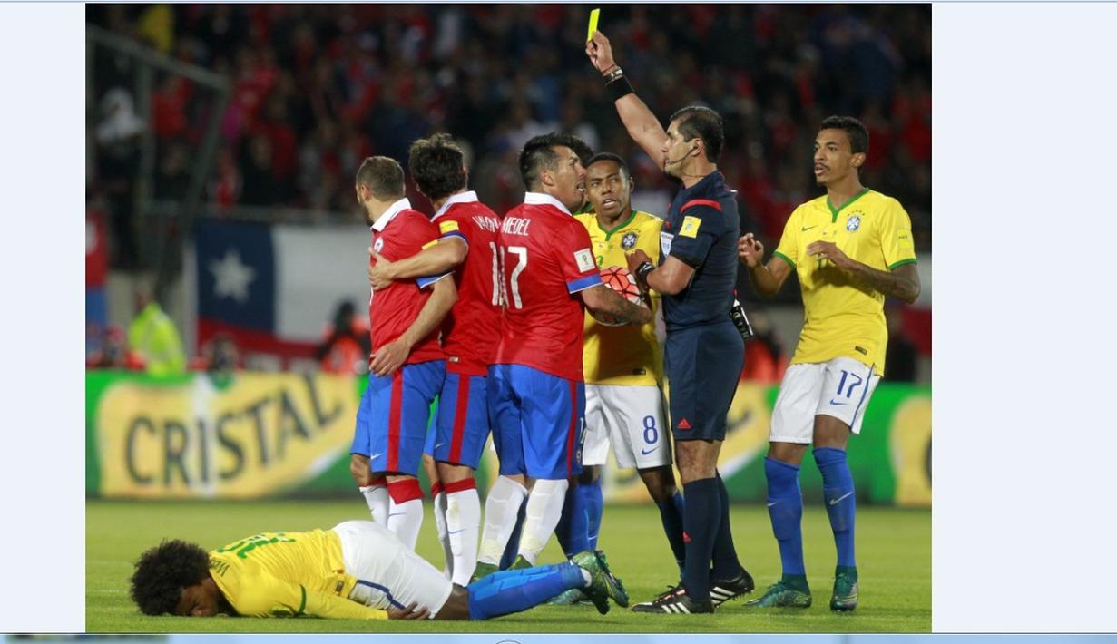 Wasit Ecuador Roddy Zambrano memberikan kartu kuning kepada pemain Chile Marcelo Diaz (kiri) pada laga kualifikasi Piala Dunia 2018 di Santiago, Chile, Kamis (08/10/2015). Chile menang 2-0. (AFP Photo/Claudio Reyes)