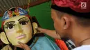 Perajin memasang kepala ondel-ondel Betawi ukuran besar saat proses pembuatan di Serpong, Tangerang Selatan, Banten, Rabu (10/10). Ondel-ondel dipasarkan dengan harga Rp 3 juta - Rp 5 juta per pasang. (Merdeka.com/Arie Basuki)