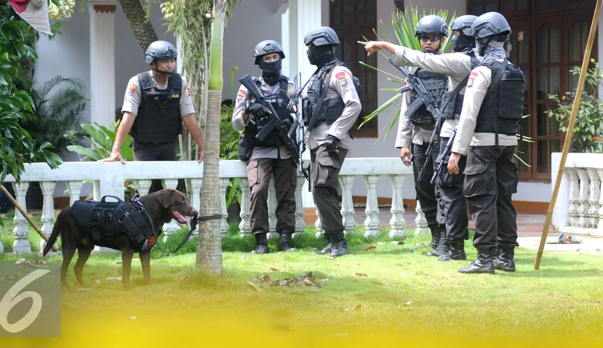 Petugas kepolisian Brimob Polda Metro Jaya mengerahkan anjing pelacak serta menyisir area tempat kejadian perkara (TKP) penggerebekan terduga teroris di setu, Tangerang Selatan, Banten, Rabu (21/12). (Liputan6.com/Helmi Affandi)
