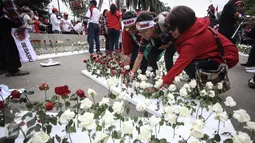 Massa menancap bunga mawar merah dan putih di sterofoam yang dijejerkan di depan Kementerian Pertanian, Jakarta, Selasa (9/5). Aksi itu diartikan sebagai bentuk rasa cinta pendukung kepada Basuki Tjahaja Purnama atau Ahok. (Liputan6.com/Faizal Fanani)