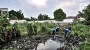 Petugas dari Dinas Sumber Daya Air membabat tanaman liar saat pembuatan Waduk Pilar Jati di Jalan Wirajasa, Cipinang Melayu, Jakarta Timur, Selasa (22/9/2020). Waduk tersebut dibuat di atas lahan Pemprov DKI seluas 7.128 meter persegi dengan kedalaman 9 meter tersebut. (merdeka.com/Iqbal Nugroho)