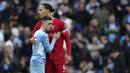 Pemain Liverpool, Virgil van Dijk (kanan) memeluk pemain Manchester City, Phil Foden pada akhir pertandingan Liga Inggris antara Manchester City dan Liverpool di Etihad Stadium, 10 April 2022. (AP/Jon Super )