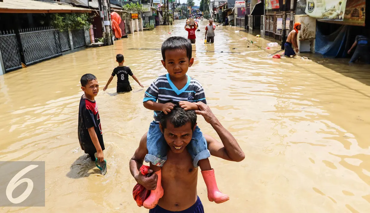 Warga melintas di kawasan banjir di Perumahan PGP Jatiasih, Bekasi, Jawa Barat, Jumat (22/4). Ketinggian air mencapai 1,5 meter dari sebelumnya ketinggian mencapai hampir 4 meter. (Liputan6.com/Fery Pradolo)