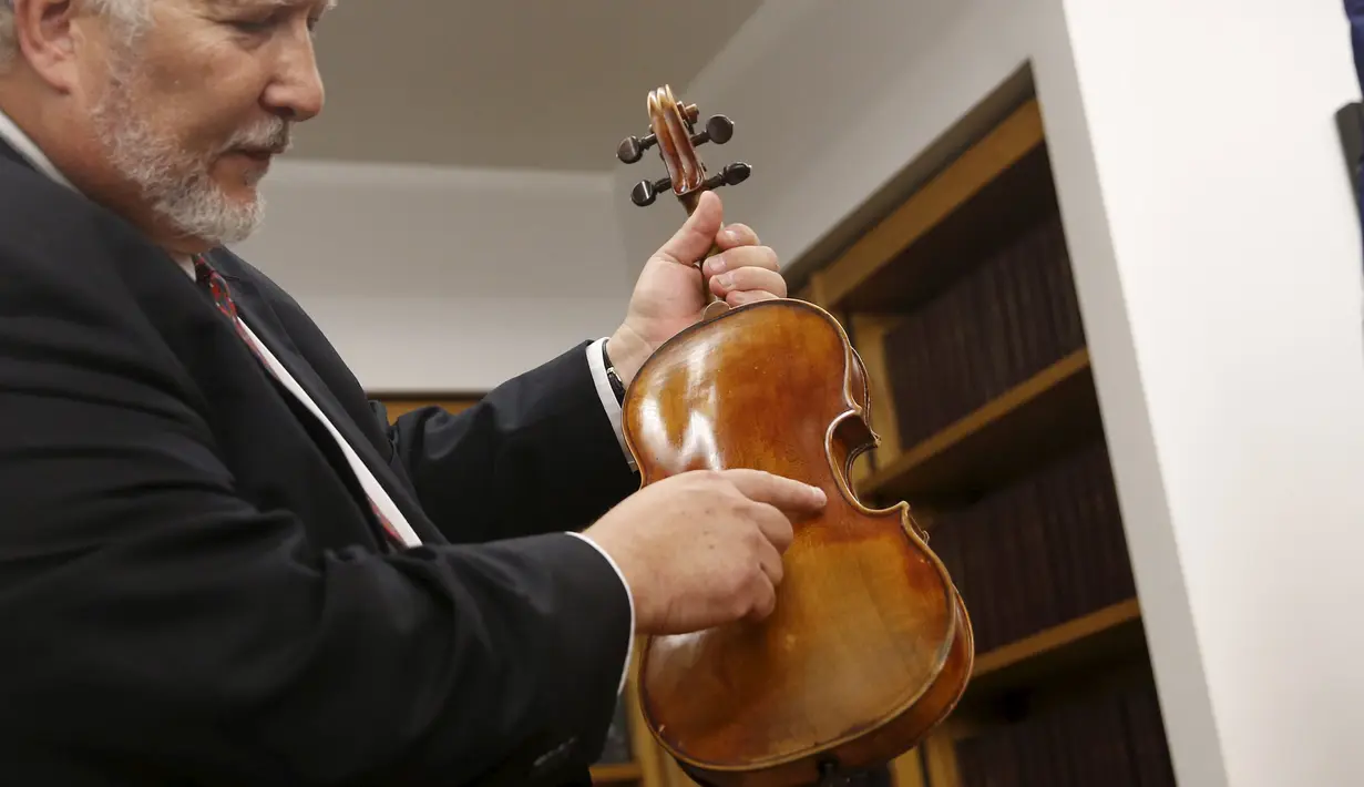 Ahli biola, Phillip Injeian menjelaskan biola Stradivarius pada konferensi pers di New York, Kamis (6/8/2015). Biola yang dibeli dengan harga Rp2,7 miliar itu kembali ke pemiliknya setelah hilang dicuri selama 35 tahun. (REUTERS/Shannon Stapleton)
