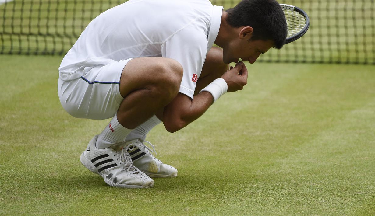 Novak Djokovic mengambil rumput lapangan dan memakannya menjadi ritual baginya bila meraih gelar Wimbledon. (EPA/FACUNDO ARRIZABALAGA)
