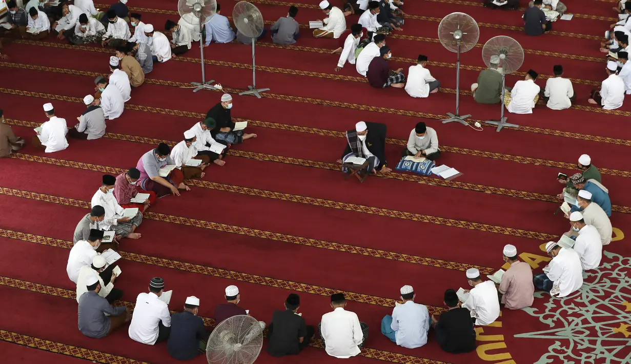 Para siswa mengenakan masker untuk membantu mengekang penyebaran COVID-19 saat membaca kitab suci Alquran di Masjid Attaqwa, Bekasi, Jawa Barat, Selasa (4/5/2021). Selama Ramadhan, umat muslim menahan diri dari makan, minum, merokok dan seks dari subuh hingga maghrib. (AP Photo/Achmad Ibrahim)