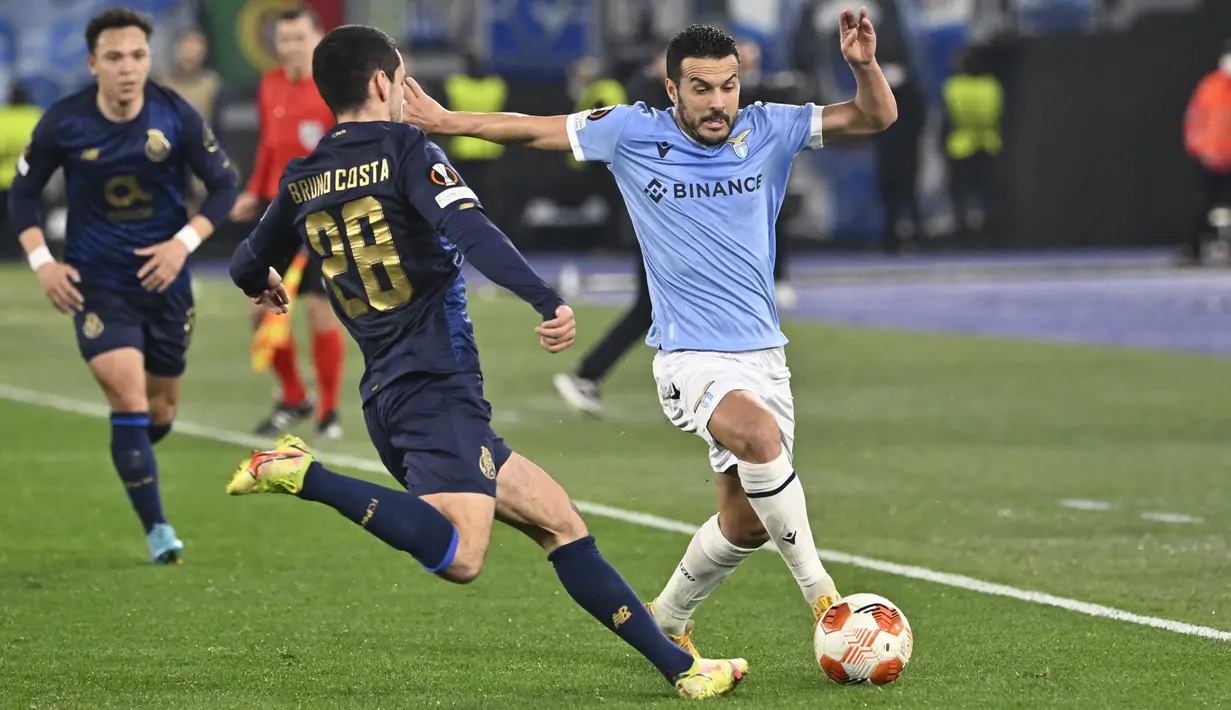 Penyerang Lazio Pedro berebut bola dengan gelandang Porto Bruno Costa pada leg kedua play-off babak 16 besar Liga Europa di Stadio Olimpico, Jumat (25/2/2022) dini hari WIB. Porto berhasil melaju ke babak 16 besar usai menahan imbang Lazio 2-2 dengan agregat 4-3 (Fabrizio Corradetti/LaPresse via AP)