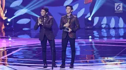Penyanyi dangdut 2R Rizki dan Ridho D'Academy menerima piala untuk kategori duo/grup dangdut terpopuler dalam ajang Indonesian Dangdut Awards 2017 di Studio 6 EMTEK CITY, Jakarta, Jumat (13/10). (Liputan6.com/Herman Zakharia)