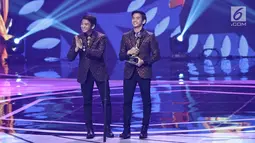 Penyanyi dangdut 2R Rizki dan Ridho D'Academy menerima piala untuk kategori duo/grup dangdut terpopuler dalam ajang Indonesian Dangdut Awards 2017 di Studio 6 EMTEK CITY, Jakarta, Jumat (13/10). (Liputan6.com/Herman Zakharia)