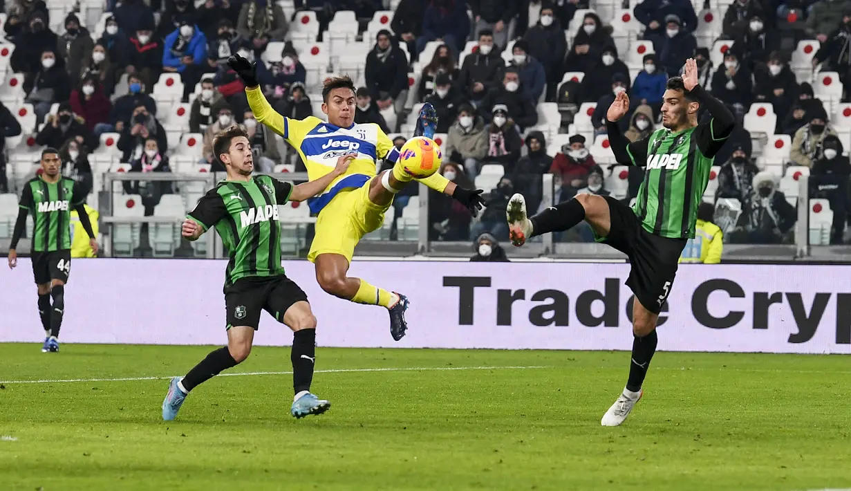 Penyerang Juventus, Paulo Dybala (tengah) berebut bola dengan dua pemain Sassuolo dalam pertandingan perempat final Coppa Italia di Stadion Allianz, Turin, Jumat (11/2/2022). Dengan kemenangan ini, Juventus berhasil melaju ke semifinal dan akan melawan Fiorentina. (Fabio Ferrari/LaPresse via AP)