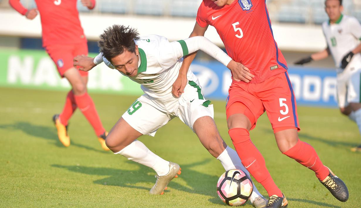 Gelandang Indonesia U-19, Muhammad Iqbal, berusaha melewati pemain Korea Selatan (Korsel) pada kualifikasi Piala Asia U-19 2018 di Stadion Paju, Sabtu (4/11/2017). Korsel menang 4-0 atas Indonesia. (AFP/Kim Doo-Ho)