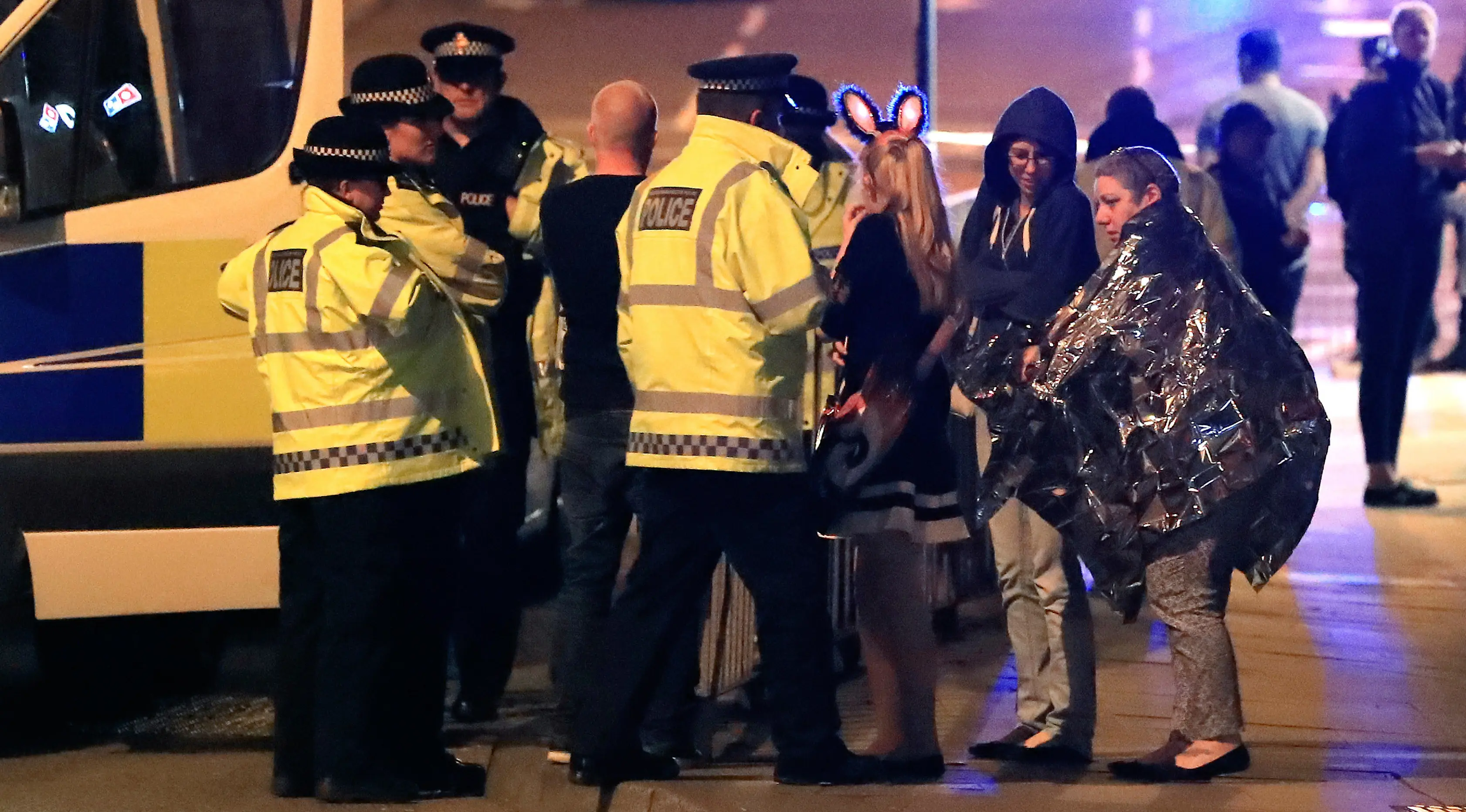 Personel darurat berbicara kepada warga di luar Manchester Arena, Inggris, usai ledakan di dalam tempat konser penyanyi Ariana Grande, Senin (22/5). Belum diketahui penyebab ledakan maupun pelaku dalam serangan tersebut. (Peter Byrne/PA via AP)