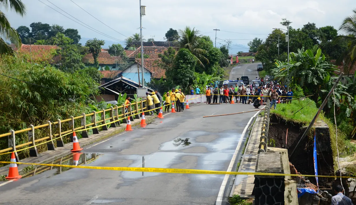 Petugas menutup Jembatan Cibaruyan yang ambrol di Kampung Sukahaji, Ciamis, Jawa Barat, Kamis (24/7/14). (ANTARA FOTO/Adeng Bustomi)