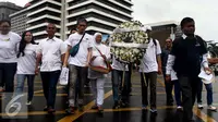 Sejumlah orang melakkukan aksi berjalan membawa buga menuju Pos Polisi di MH Thamrin, Sarinah, Jakarta, Sabtu (14/1). Aksi tersebut untuk memperingati satu tahun tragedi Bom Thamrin yang terjadi 14 Januari 2016 silam. (Liputan6.com/JohanTallo)