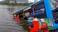 Tim penyelamat berusaha mengevakuasi sebuah bus yang jatuh ke danau di Anshun, provinsi Guizhou, China, Selasa (7/7/2020). Sedikitnya 21 orang tewas usai bus yang  membawa siswa untuk mengikuti ujian masuk perguruan tinggi atau gaokao itu menabrak pagar pembatas lalu tercebur ke danau. (STR/AFP)
