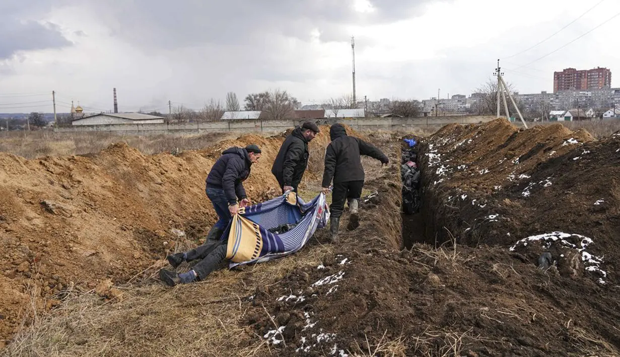 Sejumlah jenazah dimasukkan ke dalam kuburan massal di pinggiran Mariupol, Ukraina, 9 Maret 2022. Warga tidak dapat menguburkan orang mati di antara mereka karena serangan berat oleh pasukan Rusia. (AP Photo/Evgeniy Maloletka)