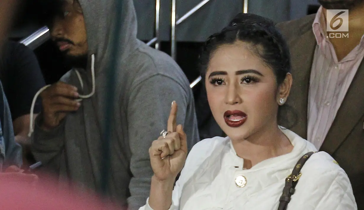 Pedangdut Dewi Persik menjawab pertanyaan awak media seusai membuat laporan di Polda Metro Jaya, Jakarta, Senin (4/12). Dewi Persik melapor balik petugas TransJakarta, Harry Maulana Saputra atas pencemaran nama baik. (Liputan6.com/Herman Zakharia)