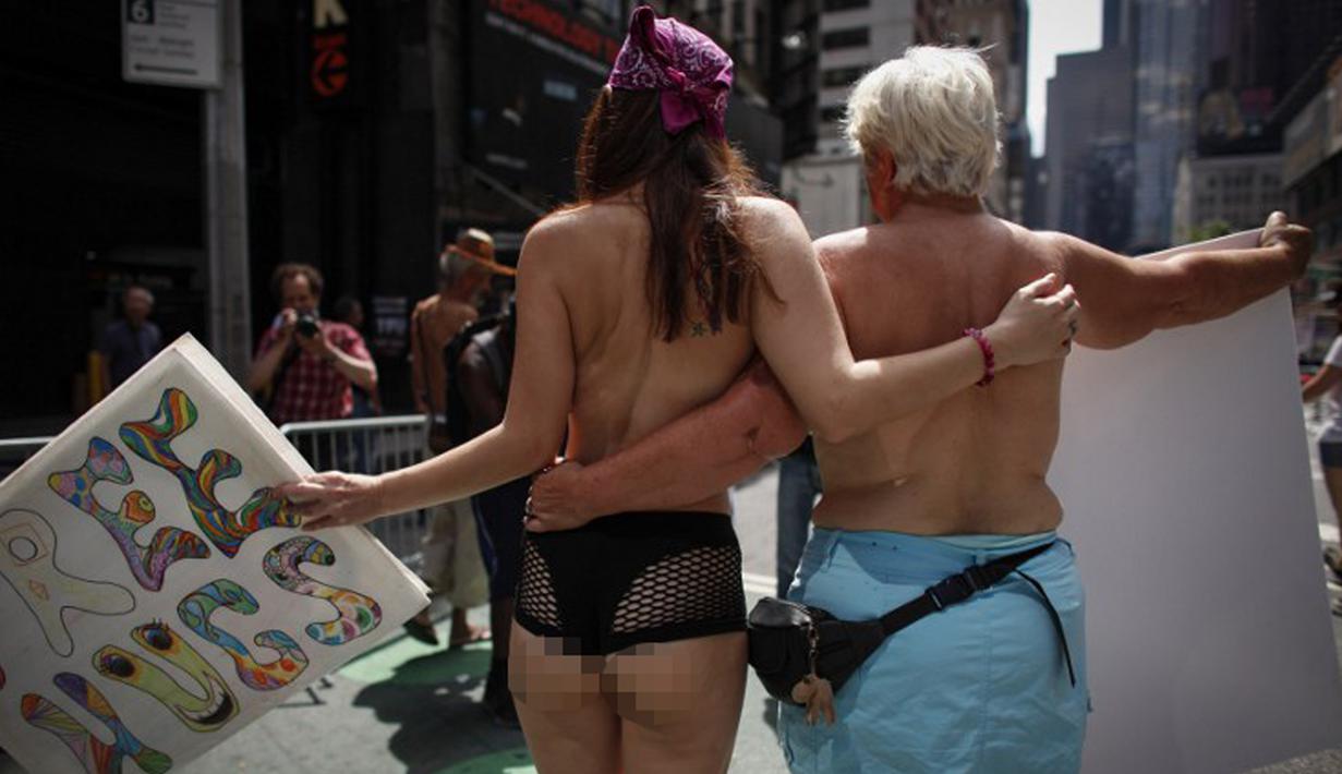 Dua orang wanita saat berpartisipasi dalam parade GoTopless di Manhattan, New York City, Minggu (23/8/2015). Aksi tersebut menuntut persamaan hak untuk bertelanjang dada seperti pria. (Kena Betancur/Getty Images/AFP)