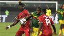 Gelandang Guinea Khatulistiwa Federico Bikoro (kiri) berebut bola dengan gelandang Mali Mohamed Camara (tengah) pada babak 16 besar Piala Afrika 2021 di Stadion Limbe, Kamis (27/1/2022) dini hari WIB. Guinea Ekuatorial mempermalukan Timnas Mali 6-5 (0-0) dalam adu penalti. (Issouf SANOGO/AFP)