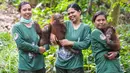 Staf bermain dengan salah satu orangutan yatim piatu di Sekolah Hutan Orangutan yang baru dibuka di Kalimantan Timur, 22 Mei 2018. Disini, orangutan diajari cara memanjat, mencari makanan, hingga cara membuat sarang di atas pohon. (HO/FOUR PAWS/AFP)