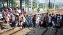 Sejumlah penumpang Comuter Line menyebrang antar peron di Stasiun Manggarai, Jakarta, Selasa (28/3). Jumlah kenaikan penumpang pada hari libur Nyepi ini meningkat hingga 70 % dibanding hari biasa. (Liputan6.com/Faizal Fanani)