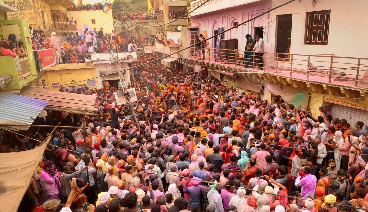 Perempuan India dari desa Barsana memukuli seorang warrga dari Nandgoan dengan tongkat kayu selama perayaan festival Lathmar holi di Barsana, India, Selasa (23/3/2021). Lathmar Holi adalah perayaan lokal festival Hindu Holi, biasanya beberapa hari sebelum festival Holi. (AP Photo)