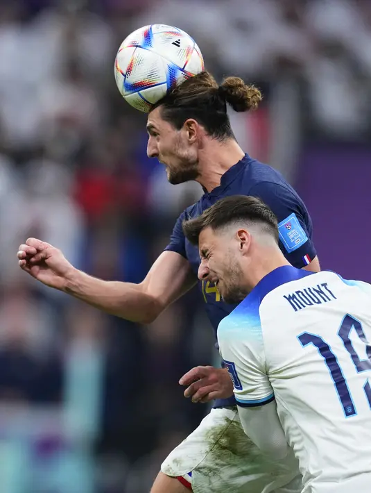 Gelandang Prancis Adrien Rabiot menyundul bola menjauh dari gelandang Inggris Mason Mount pada perempat final Piala Dunia 2022 di Al Bayt Stadium, Al Khor, Minggu (11/12/2022) dini hari WIB. Dua gol kemenangan Prancis diciptakan Aurelien Tchouameni dan Olivier Giroud. (AP Photo/Natacha Pisarenko)