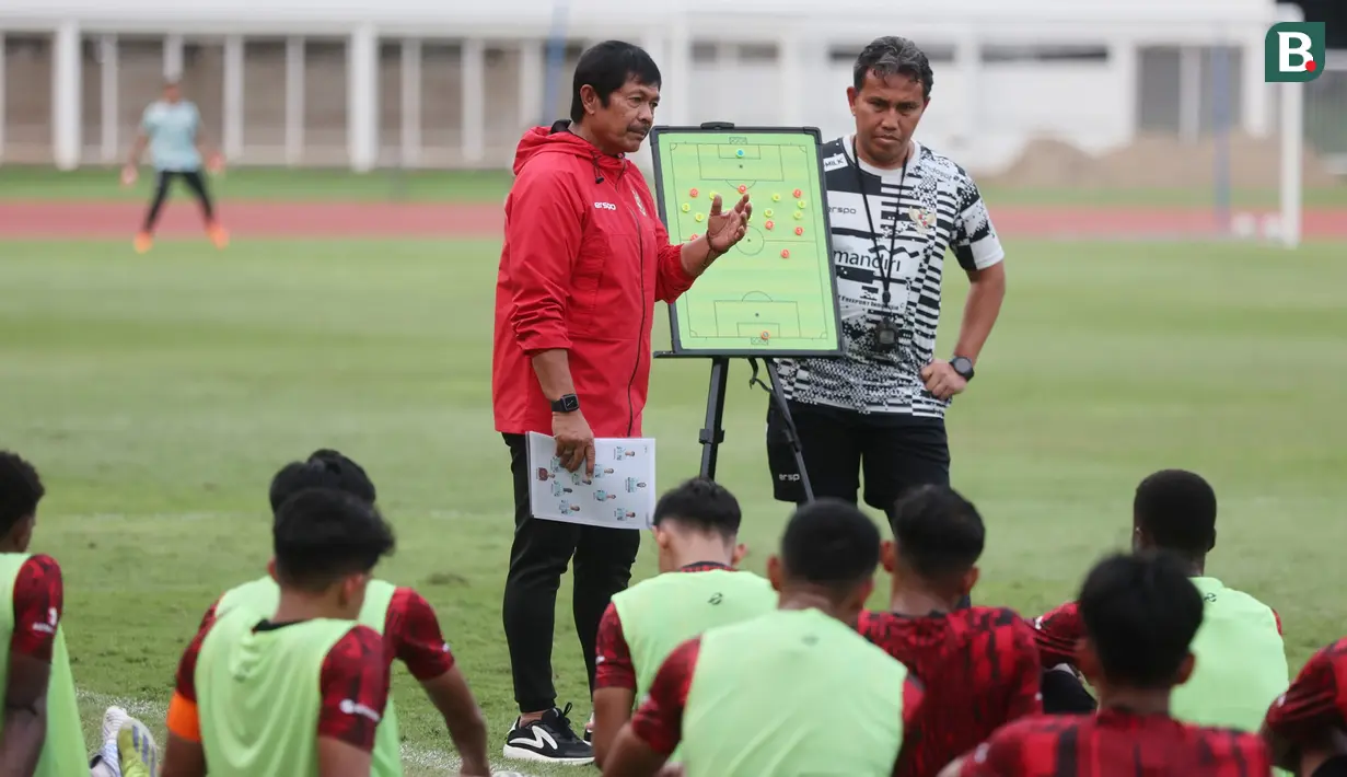 <p>Pelatih kepala Timnas Indonesia U-19, Indra Sjafri (kiri) didampingi asisten pelatih, Bima Sakti memberi pengarahan kepada para pemainnya dalam rangkaian pemusatan latihan Timnas Indonesia U-19 di Stadion Madya, Senayan, Jakarta, Senin (1/7/2024) sebagai persiapan menghadapi ajang Piala AFF U-19 2024 yang akan berlangsung pada 17 hingga 29 Juli 2024. (Bola.com/M Iqbal Ichsan)</p>