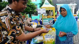 Petugas melayani warga yang membeli bahan kebutuhan pokok dengah harga di bawah harga eceran tertinggi (HET) saat kegiatan operasi pasar di Kantor Kelurahan Sawah, Tangerang Selatan, Banten, Kamis (29/9/2022). Dinas Perindustrian dan Perdagangan (Disperindag) Kota Tangerang Selatan menggelar operasi pasar di tujuh kecamatan dalam rangka penanganan inflasi sebagai dampak kenaikan harga bahan bakar minyak (BBM). (merdeka.com/Arie Basuki)