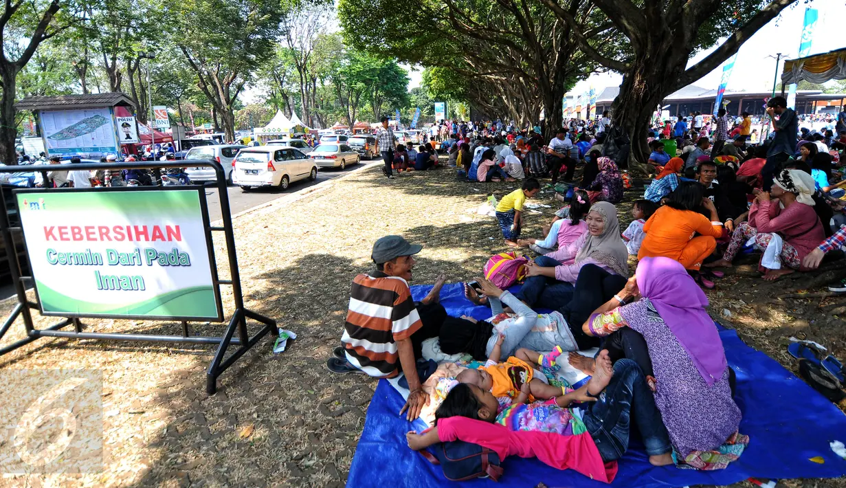 Sejumlah pengunjung beristirahat di area wisata Taman Mini Indonesia Indah, Jakarta, Minggu (19/07/2015). Makan bersama sambil menggelar tiker di tempat wisata menjadi pilihan warga yang mengunjungi tempat wisata TMII. (Liputan6.com/Yoppy Renato)