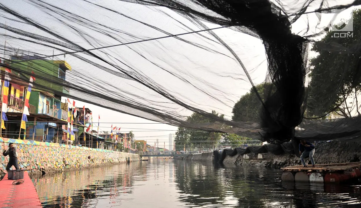 Petugas Dinas Sumber Daya Air DKI Jakarta memasang waring di Kali Sentiong atau Kali Item, Tanjung Priok, Selasa (31/7). Pemprov DKI Jakarta menambah pemasangan waring sepanjang 100 m hingga Stasiun Pompa Kali Item. (Merdeka.com/Iqbal S Nugroho)