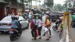 Pejalan kaki menyeberangi jalan di depan Stasiun Lenteng Agung, Jakarta, Senin (4/11/2019). Meski telah tersedia JPO, sebagian pejalan kaki lebih memilih untuk menyeberang sembarangan sehingga mengganggu arus lalu lintas serta berpotensi menimbulkan kecelakaan. (Liputan6.com/Immanuel Antonius)