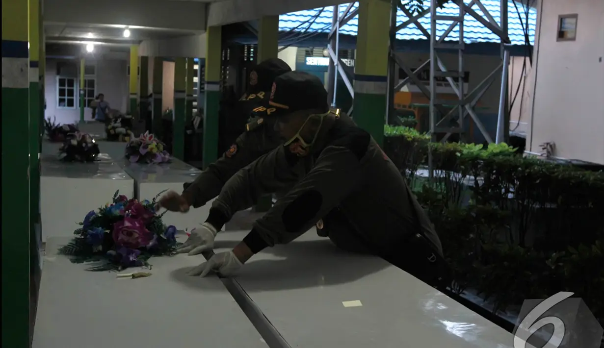 Petugas dari tim SAR menaruh karangan bunga pada peti jenazah untuk penumpang AirAsia QZ8501 di RSUD Sultan Imanuddin, Pangkalan Bun, Kalimantan Tengah, Kamis (1 /1/2015). (Liputan6.com/Herman Zakharia)
