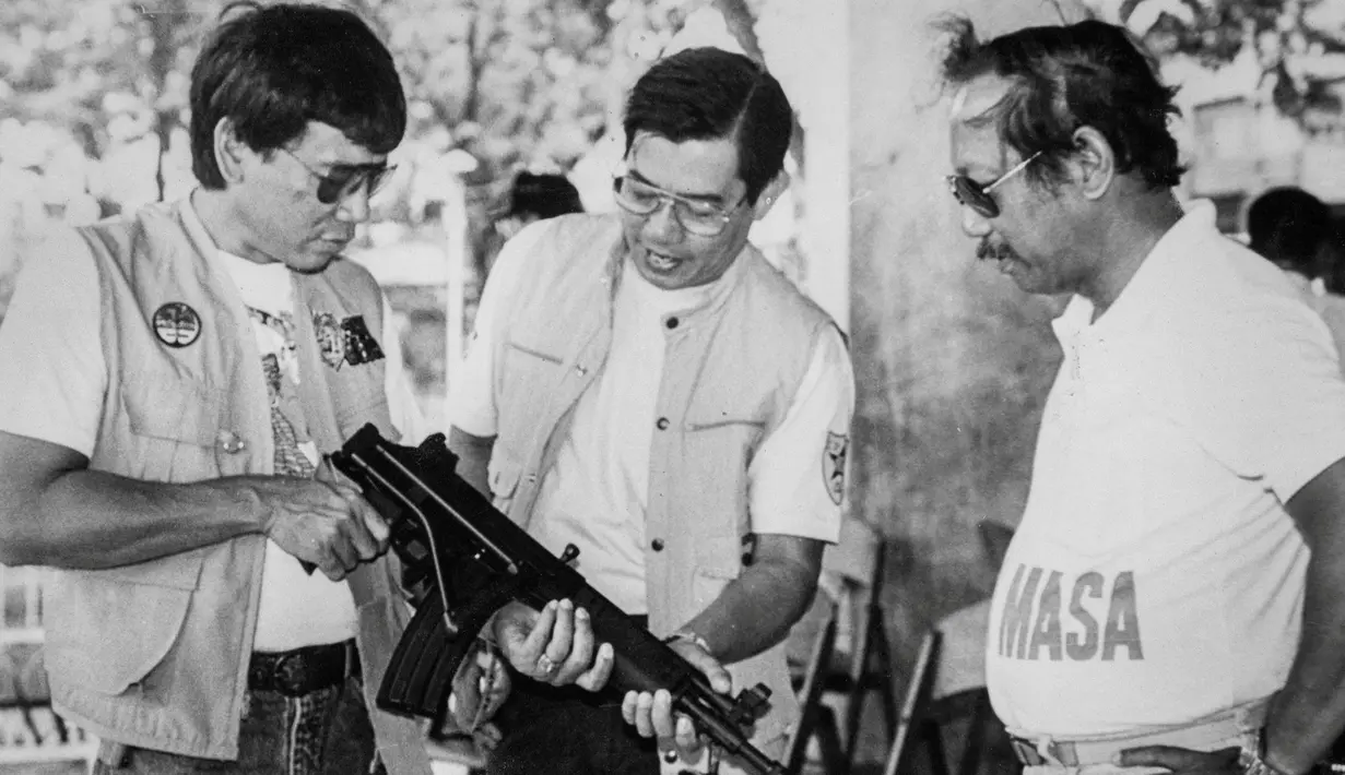 Rodrigo Duterte (kiri) yang masih menjabat sebagai Wali Kota memeriksa senapan serbu bersama Kepala Kepolisian Daerah, Miguel Abaya dan Kepala Metrodiscom, Franco Calida, pada akhir 1980-an di kota Davao di Filipina selatan. (REUTERS/Renato Lumawag)