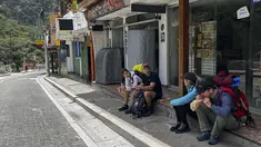 Turis menunggu di luar stasiun kereta Machu Picchu setelah layanan kereta api dihentikan karena kerusakan yang diduga disebabkan oleh pengunjuk rasa di Machu Picchu, Peru, Sabtu (21/1/2023). Demonstrasi besar di Peru yang menentang pemerintahan masih belum usai dan menyebabkan tempat wisata terkenal Machu Picchu ditutup. (Photo by Carolina Paucar / AFP)