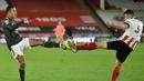 Striker Manchester United, Mason Greenwood (kiri), berebut bola dengan bek Sheffield United, Enda Stevens, dalam laga lanjutan Liga Inggris 2020/21 pekan ke-13 di Bramall Lane, Sheffield, Kamis (17/12/2020). Manchester United menang 3-2 atas Sheffield United. (AFP/Peter Powell/Pool)