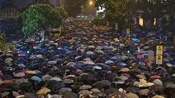 Ribuan pegawai negeri sipil (PNS) mengenakan payung saat mengikuti unjuk rasa menolak RUU Ekstradisi di Hong Kong, Jumat (2/8/2019). PNS mendesak pihak berwenang untuk membangun kembali kepercayaan pada pemerintah. (ANTHONY WALLACE/AFP)