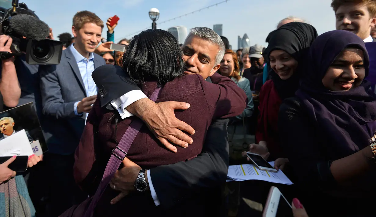 Walikota London Sadiq Khan dipeluk pendukungnya saat tiba untuk hari pertamanya bekerja di Balai Kota di London, Inggris (9/5). Kandidat dari kubu Buruh ini mengalahkan rival terdekatnya dari kubu Konservatif, Zac Goldsmith. (REUTERS / Hannah McKay)