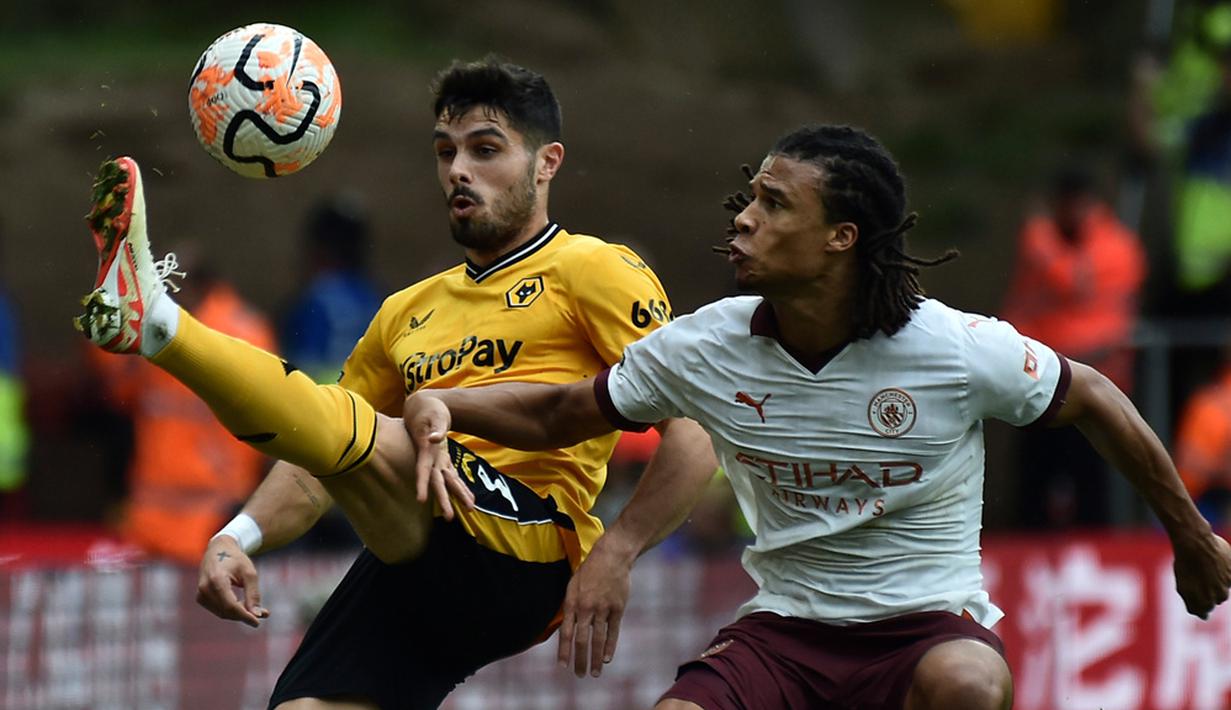 Pemain Wolverhampton Wanderers Pedro Neto (kiri) mengontrol bola melewati pemain Manchester City Nathan Ake pada pertandingan sepak bola Liga Inggris di Stadion Molineux, Wolverhampton, Inggris, Sabtu (30/9/2023). Wolverhampton Wanderers mengalahkan Manchester City dengan skor 2-1. (AP Photo/ Rui Vieira)